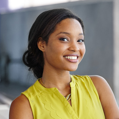 A young woman with a radiant smile, posing for the camera with a confident posture.