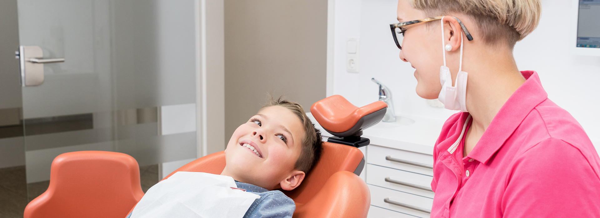 An image of a dental office with a dentist and patient, likely used for educational or promotional purposes.