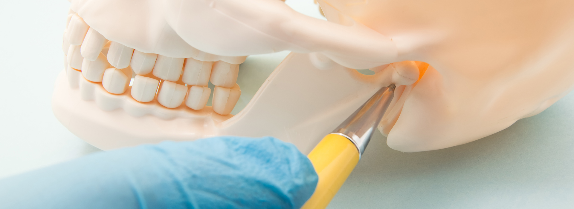 The image shows a close-up of a person s teeth being worked on by a dental professional, with a toothbrush and dental tools visible, as well as a yellow object that could be an instrument or a tool.