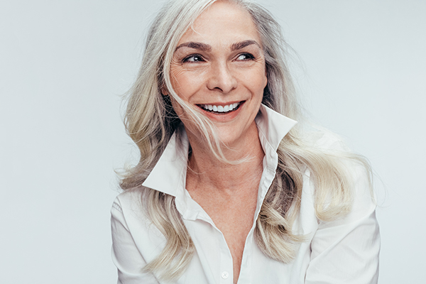 A woman with short gray hair, smiling at the camera.